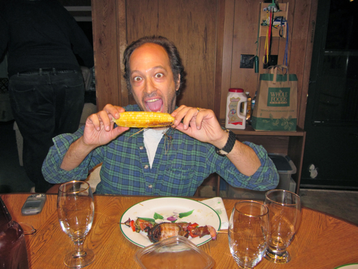 David, showing off the fine cuisine of beef shishkebob, corn-on-the-cob, bacon-wrapped venison loins and salad.